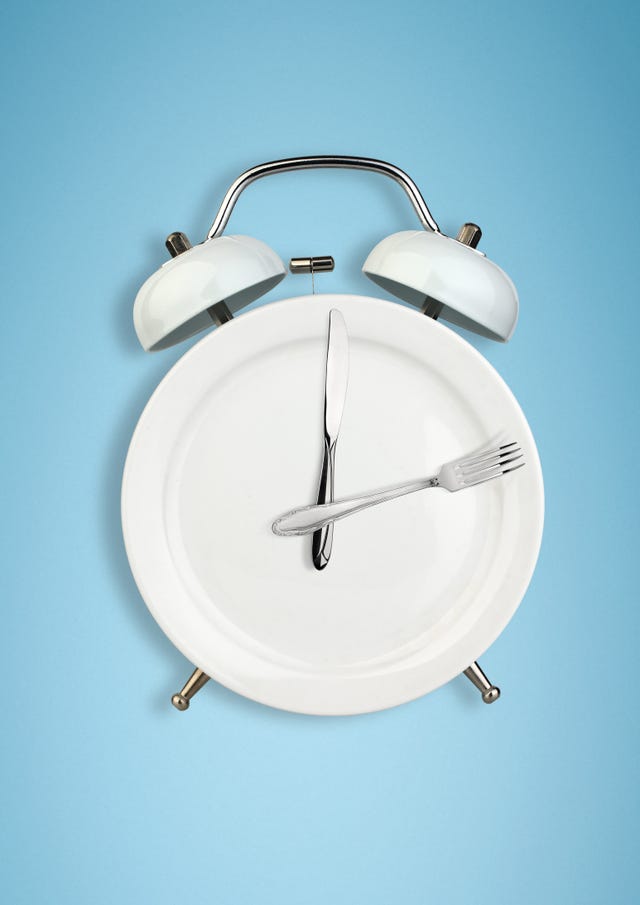 Intermittent fasting concept, food and weight loss plate as a blue alarm clock